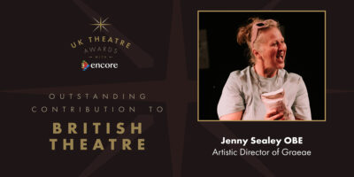 Text reads: UK Theatre Awards Outstanding Contribution to British Theatre, Jenny Sealey OBE, Artistic Director of Graeae. Image shows: Jenny Sealey smiling. She is holding a bag of flour, wearing a grey t-shirt and has a pair of pink sunglasses on top of her head.