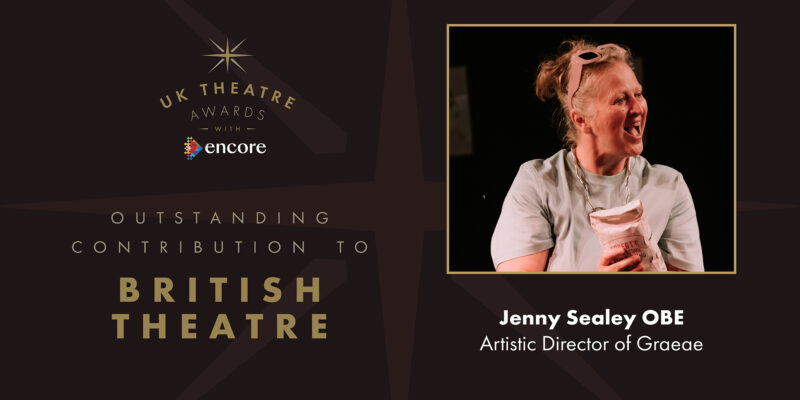 Text reads: UK Theatre Awards Outstanding Contribution to British Theatre, Jenny Sealey OBE, Artistic Director of Graeae. Image shows: Jenny Sealey smiling. She is holding a bag of flour, wearing a grey t-shirt and has a pair of pink sunglasses on top of her head.