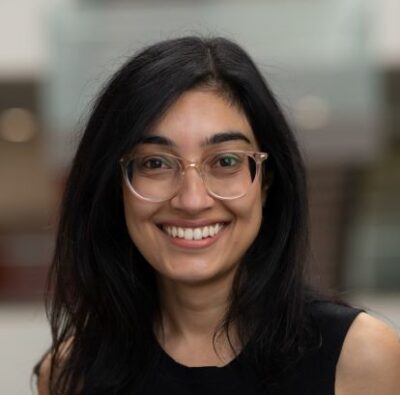 Smiling portrait of Feeroza Patel with shoulder length black hair and glasses