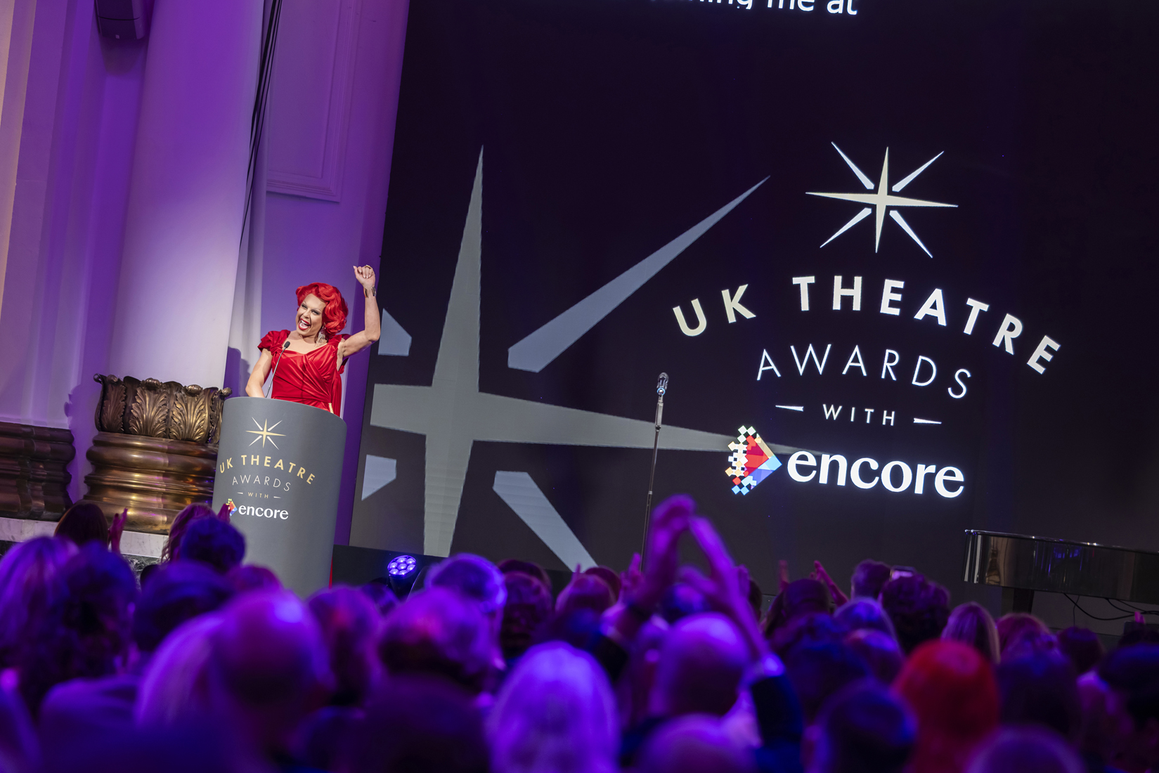 147_UKTA 2026_Pamela Raith Photography (1) La Voix raises her hand in the air in celebration on the stage of the UK Theatre Awards 2026